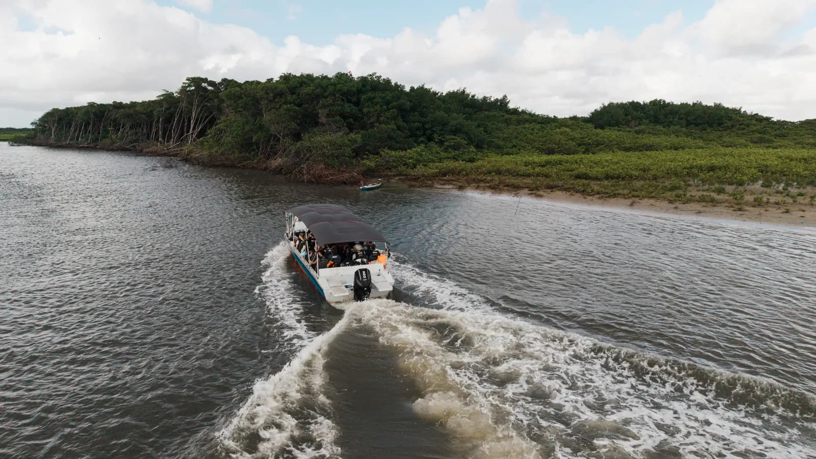 Bateau à moteur sur la rivière entre la végétation, sur le chemin d'Atins
